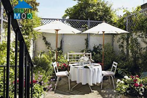 Bộ bàn ghế cùng những chiếc ô trắng đem lại sự lãng mạn cho khu vườn yên tĩnh