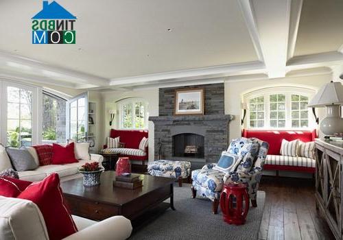Phòng khách này mang chút hơi hướng vintage với ghế bành in hoa nổi màu xanh dương và gối tựa sofa màu đỏ