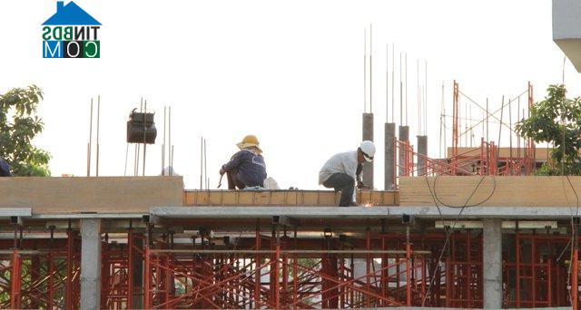 Các công nhân đang xây dựng trên công trường một dự án nhà ở tại Quận 2, Tp. HCM vào chiều ngày 2/2/2016. 