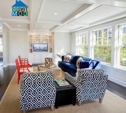 Tường phòng khách màu trắng rất hợp gu với sofa xanh dương và ghế thư giãn đỏ