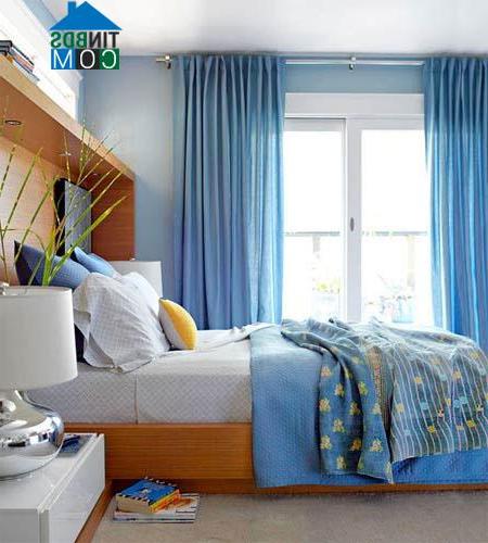 Phòng ngủ bừng sáng với rèm, ga màu xanh điểm thêm sắc vàng tươi của gối