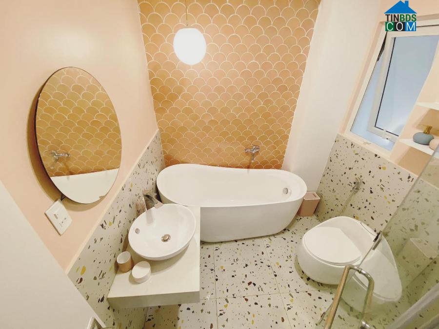 Phòng tắm ấn tượng với tường ốp gạch mosaic vảy cá màu hồng cam nổi bật.