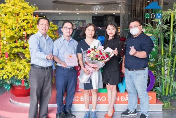 Đại diện đơn vị phân phối bàn giao sổ hồng cho khách hàng.